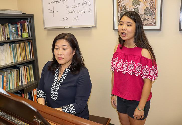 Student singing with professor